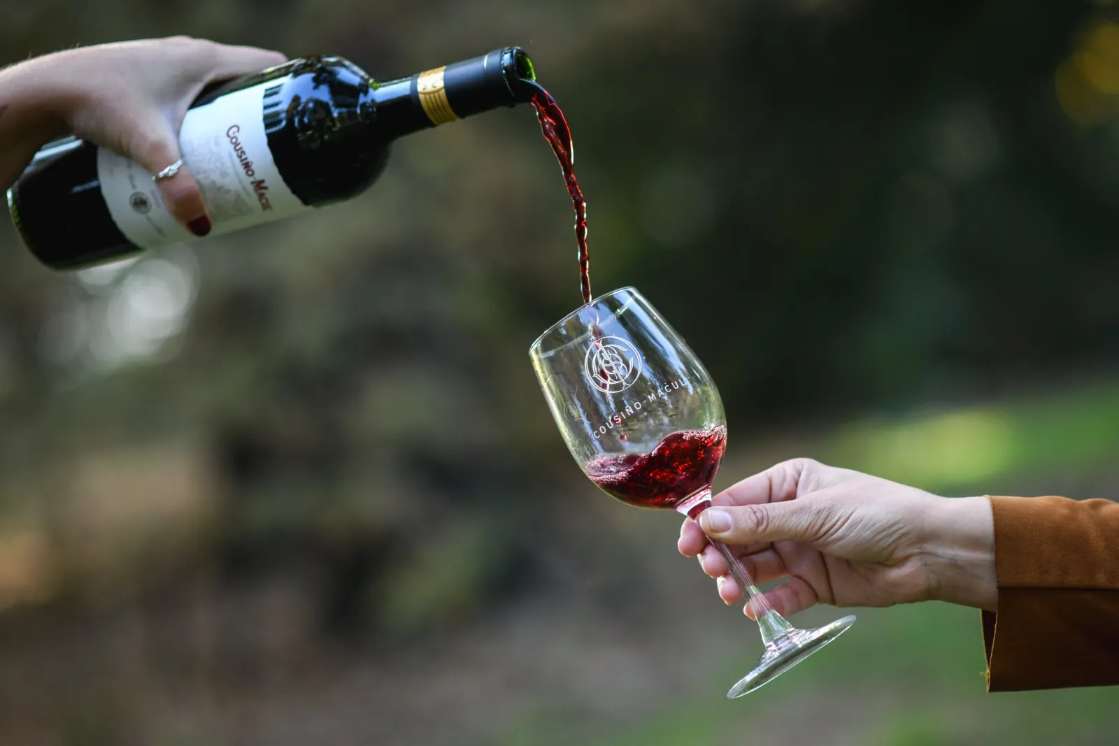 Cousiño Macul red wine poured into a glass engraved with the winery crest