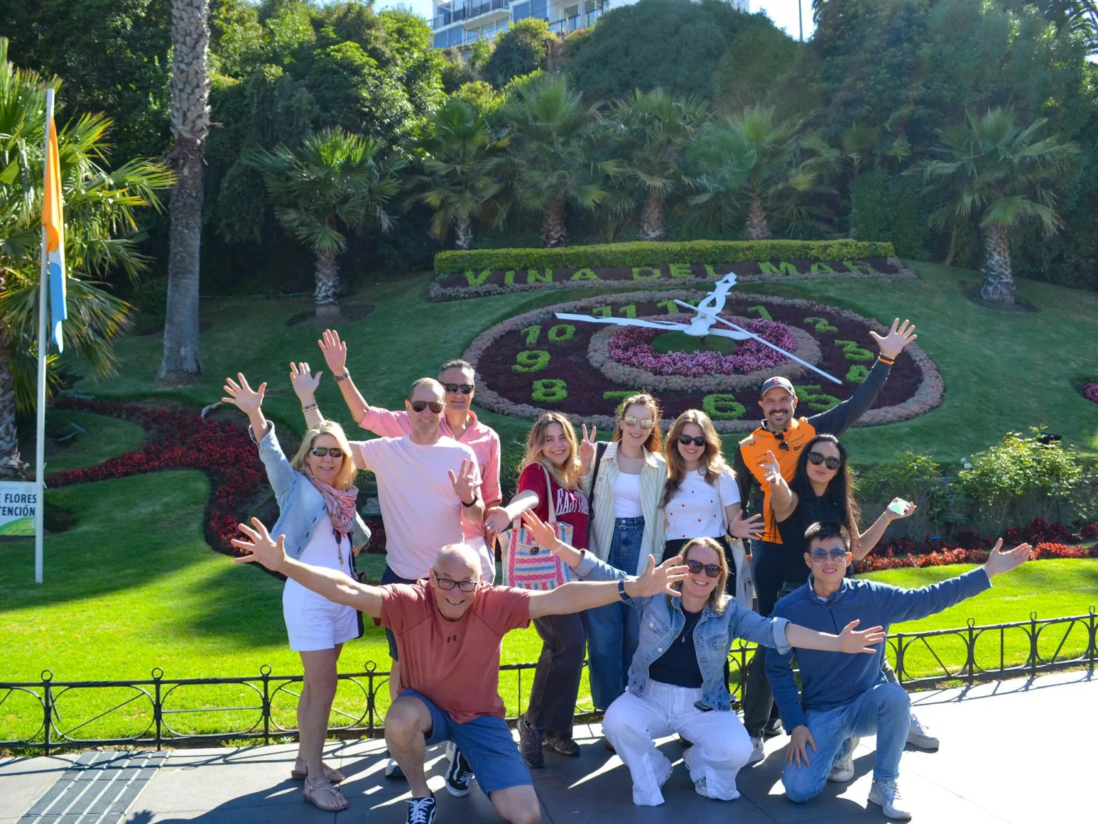 Group posing with raised arms before the Viña del Mar flower clock