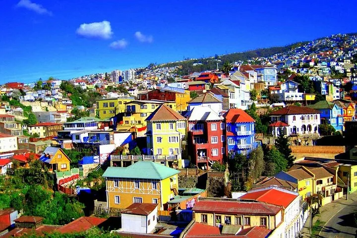 Colorful painted houses climbing a Valparaíso hillside under a deep blue sky