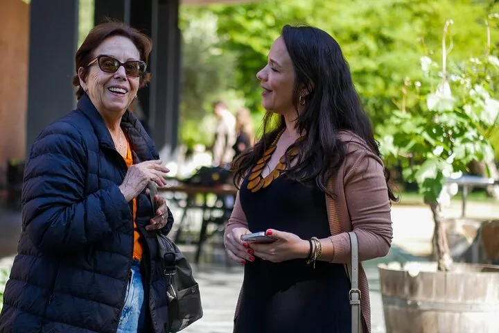 Two women talking and laughing on a sunny winery patio