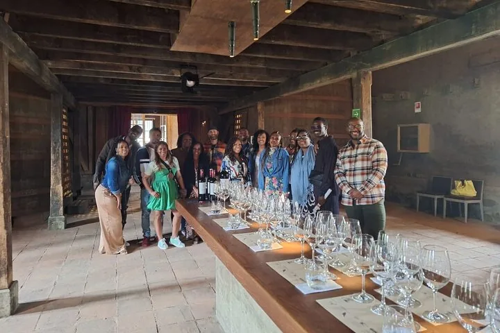 Group of visitors behind a long tasting table set with rows of glasses