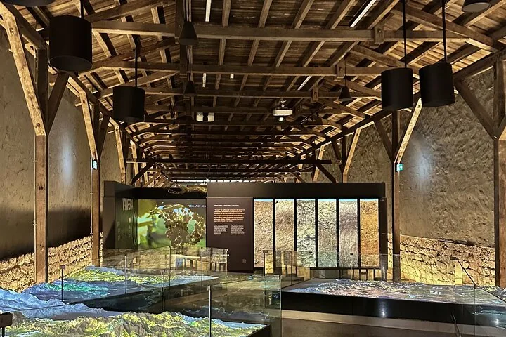 Timber-roofed exhibition hall with a lit relief map of wine valleys