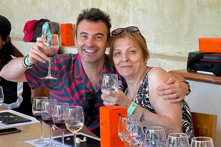 Two guests raising a glass behind a line of tasting glasses