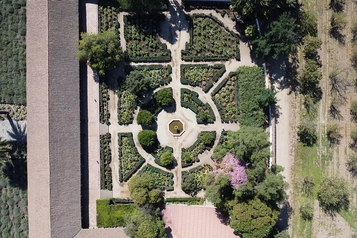 Aerial view of a formal garden with hedged beds around a central fountain